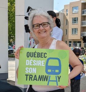Linda Forgues tient une pancarte Québec désire son tramway